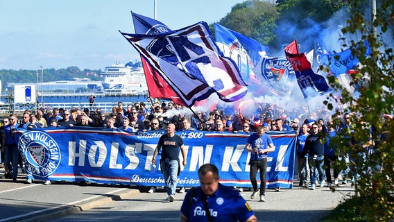 Kiels Fans marschieren vor dem Jachthafen zum Stadion © picture alliance Foto: Michael Schwartz