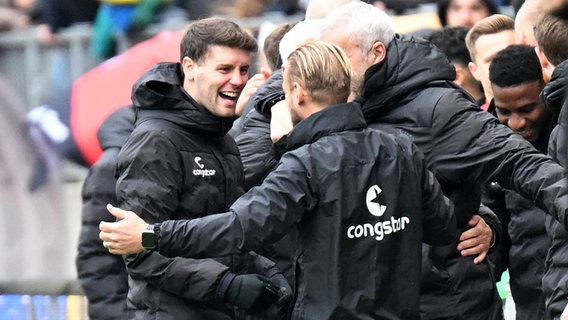 St. Paulis Trainer Fabian Hürzeler (l.) und sein Team jubeln. © IMAGO / Lobeca 