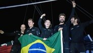 Das Team Malizia jubelt und hält eine brasilianische Flagge © Marie Lefloch 