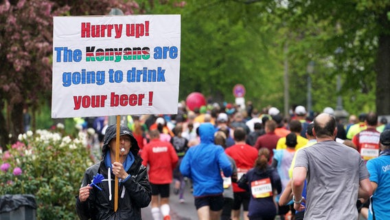 Ein Zuschauer feuert die Läufer beim Hamburg-Marathon mit einem Plakat an. © Witters 