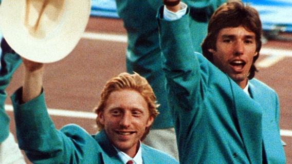 Boris Becker (l.) und Michael Stich ziehen 1992 in Barcelona mit der deutschen Olympia-Mannschaft ins Stadion ein. © picture-alliance / dpa 