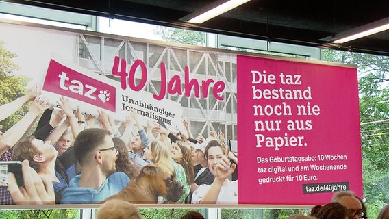 Die "taz" feiert ihren 40. Geburstag - und es gibt sie bald wochentags nur noch digital. Beides ist auf einem Plakat zu lesen. © NDR 