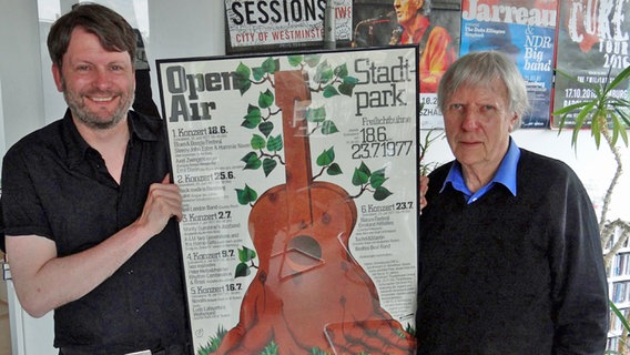 Konzertveranstalter Karsten Jahnke und sein Kommunikationschef Frehn Hawel halten ein altes Plakat vom Stadtpark Open Air. Konzertveranstalter Karsten Jahnke und sein Kommunikationschef Frehn Hawel halten ein altes Plakat vom Stadtpark Open Air. © NDR Foto: Heiko Block