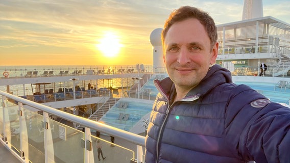 Matthias Morr steht bei untergehender Sonne auf einem Schiff. © Matthias Morr Foto: Matthias Morr