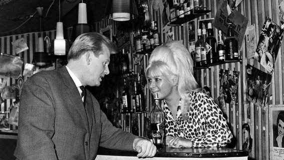 Manfred Weissleder, der Betreiber des Star-Clubs in Hamburg, am 13.06.1964 gemeinsam mit einer Angestellten an der Bar. © picture alliance / dpa Foto: Lothar Heidtmann