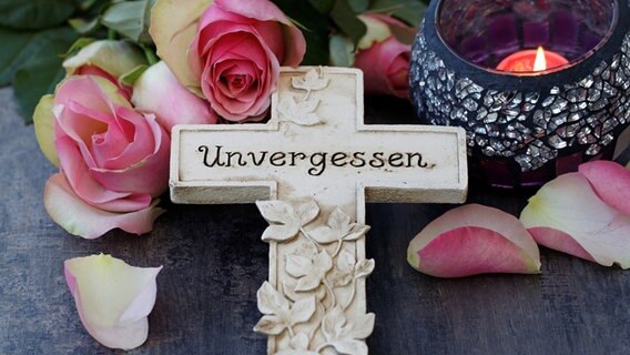 Auf einem kleinen Kreuz steht "unvergessen". © fotolia Foto: racamani