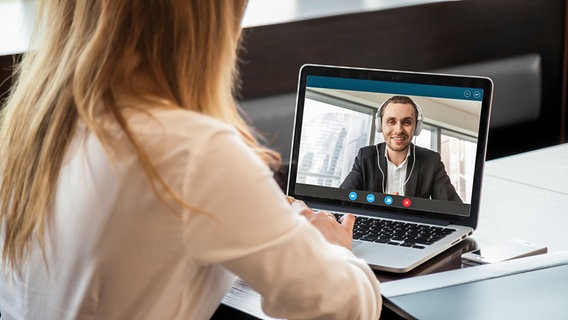 Eine Frau sitzt an einem Laptop, auf dem ein Mann beim Videochat zu sehen ist. © Colourbox Foto: Aleksandr