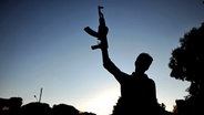 Mann in Syrien hält eine Waffe in die Luft. © dpa bildfunk 