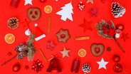 Weihnachtsdeko, Kerzen und Kekse auf rotem Hintergrund. © photocase Foto: MichaelJBerlin