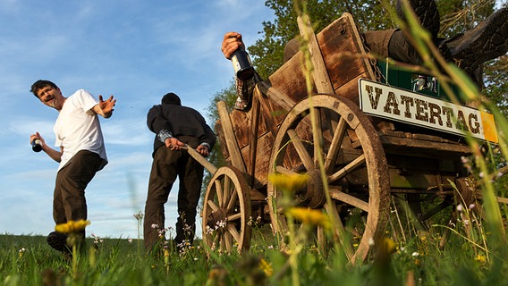 Ein Mann zieht einen Bollerwagen, in dem ein Freund sitzt. © Fotolia Foto: Ingo Bartussek