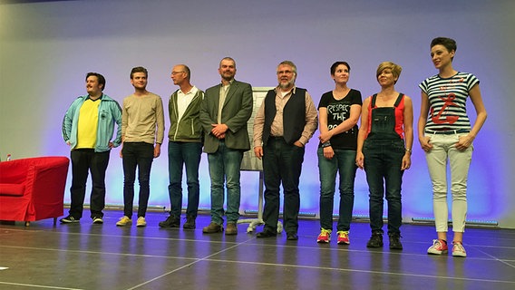 Acht Peotry-Slammer stehen nebeneinander in Büdelsdorf auf der Bühne. © NDR Foto: Lornz Lorenzen