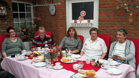 Rosemarie Carstens (2. v.r.) sitzt mit ihrer Familie bei Kaffeekranz am Tisch im Garten. © NDR Foto: Cassandra Arden