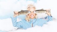 Moderatorin Ina Müller hält sich zwei Fische aus Kunststoff vors Gesicht © Sandra Ludewig Foto: Sandra Ludewig