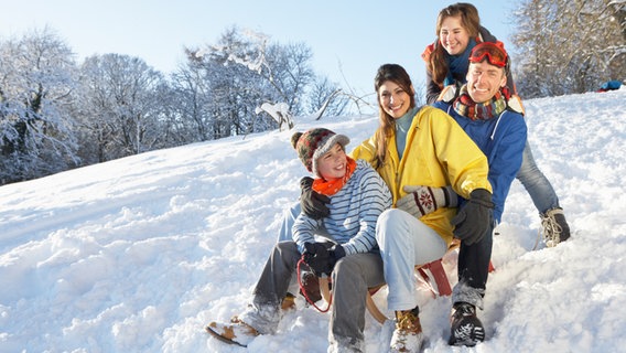 Eine Familie im Winter auf einem Schlitten © colourbox Foto: -